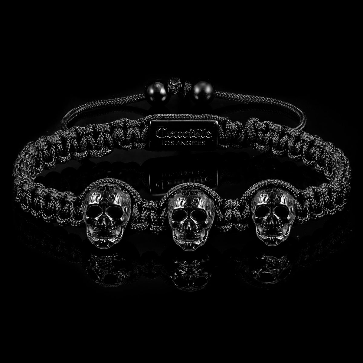 Crucible Jewelry Three Black IP Skulls on Shocker Tie Woven Bracelet